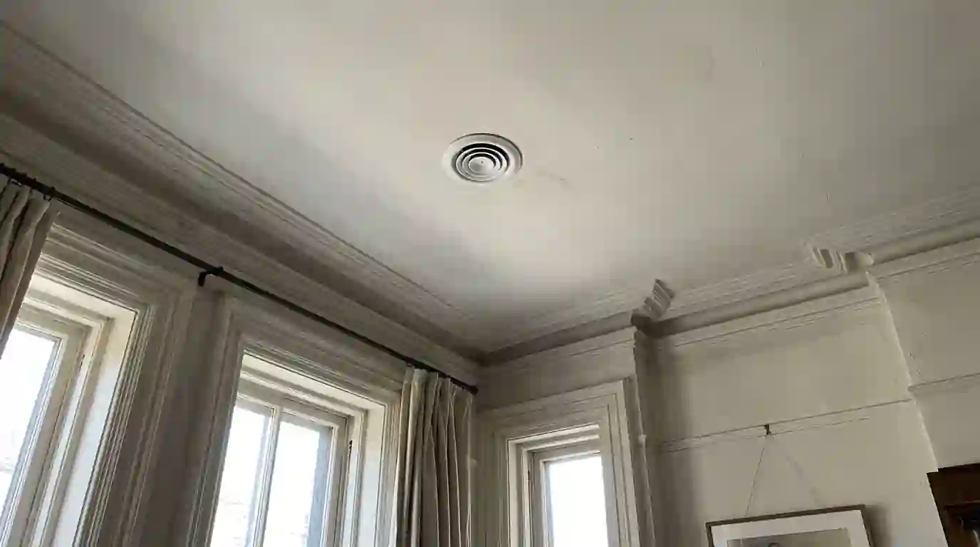 Round high-velocity air outlet in a plaster ceiling